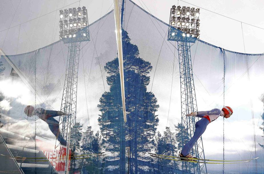 Il “doppio” salto dal trampolino del tedesco Markus Eisenbichler (a sinistra la sua immagine riflessa) (Reuters)
